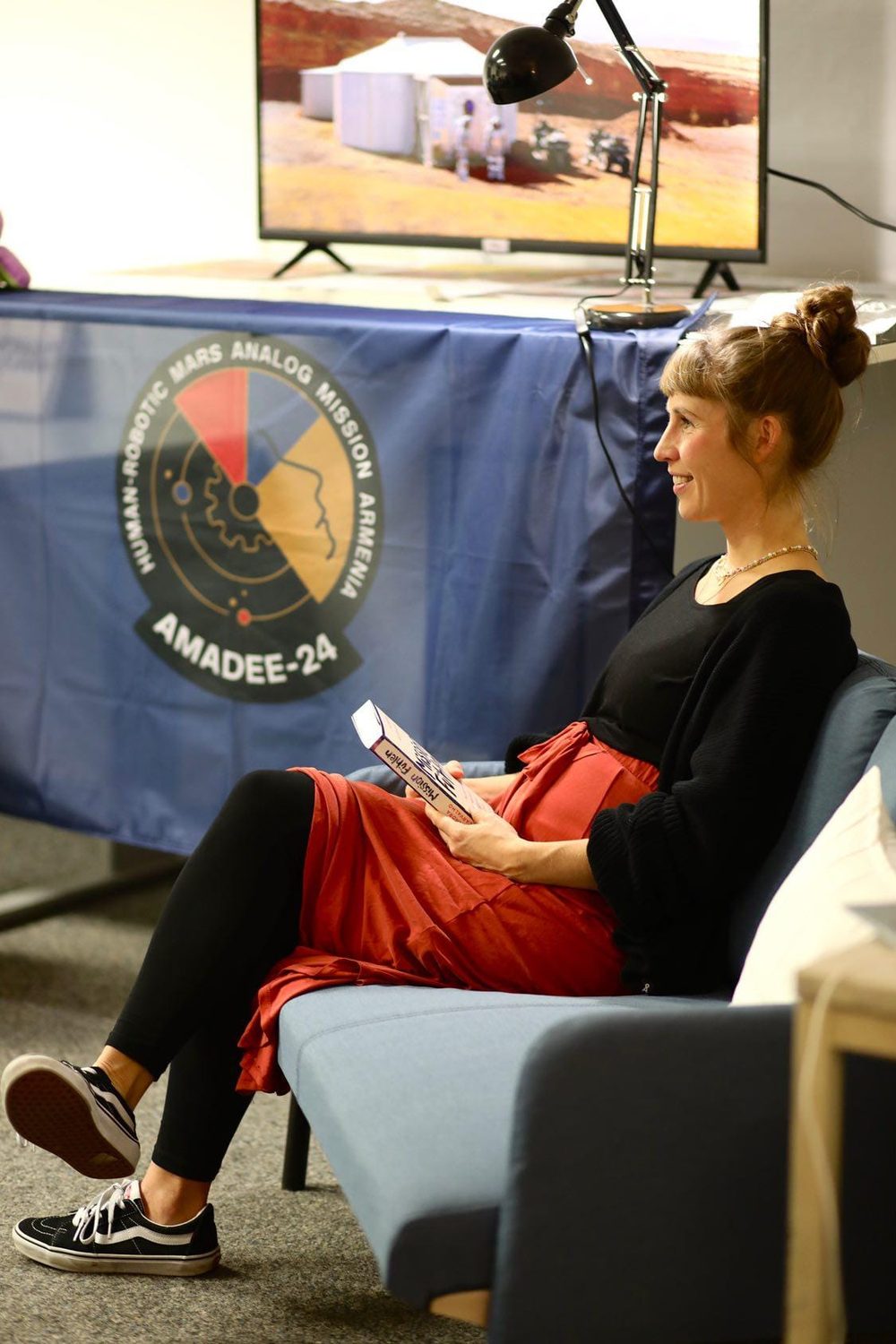Alexandra de Carvalho liest aus „Mission Fühlen“, hinter ihr das Banner der Mars-Analogmission AMADEE-24